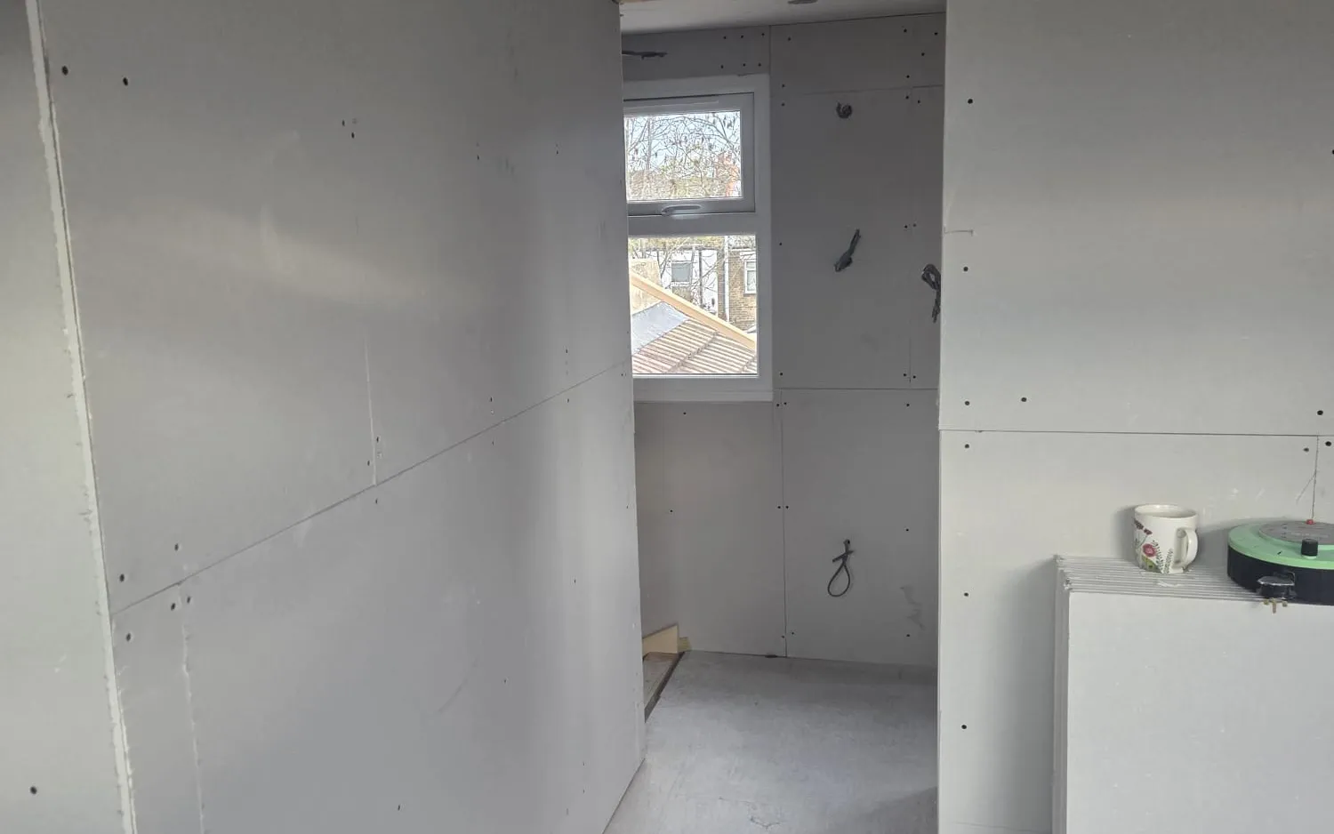 Rear box dormer loft conversion in Beckenham, the new suite plastered with a window during the build