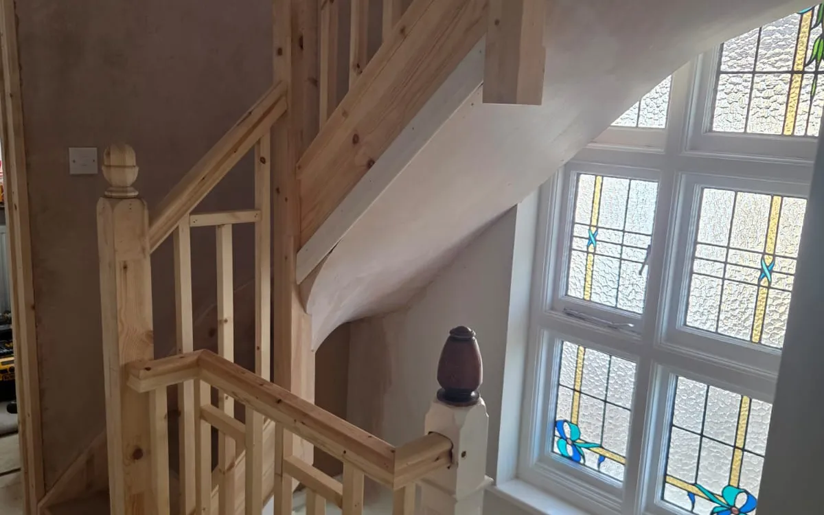 New timber staircase in a Beckenham loft conversion, built around the original stained-glass window