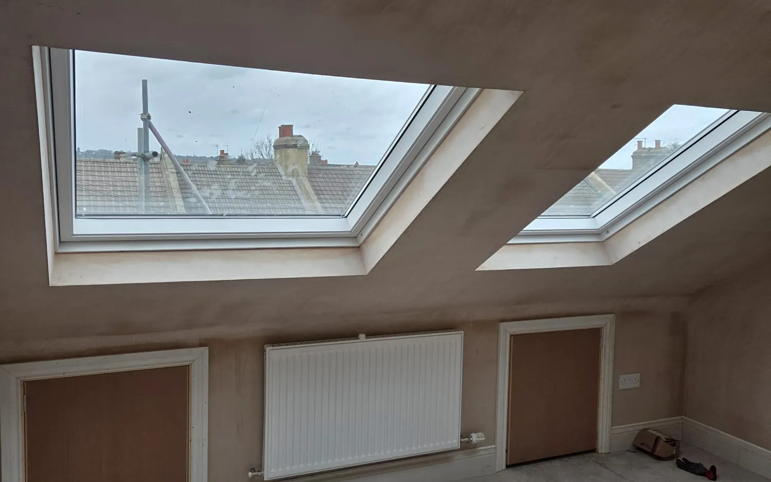 Two-bedroom loft conversion in Beckenham with two large skylights, rooftop views, a radiator and built-in eaves storage