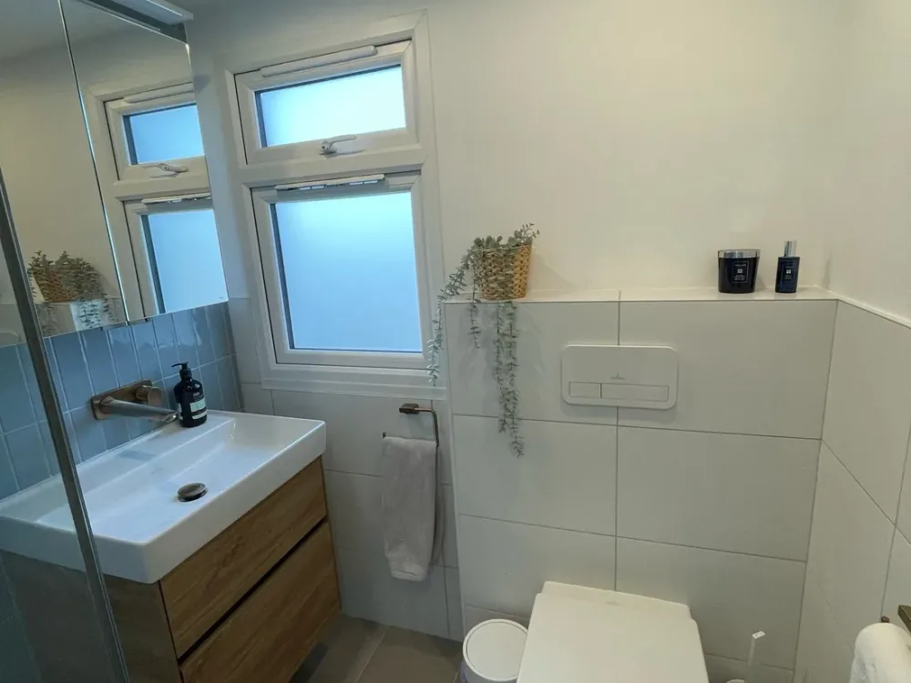 Small loft ensuite with a wall-hung WC, vanity and a dormer window