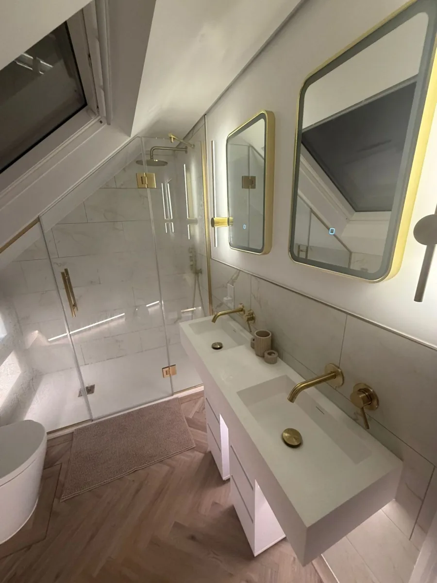En-suite vanity with a wall-hung basin and brushed brass fittings