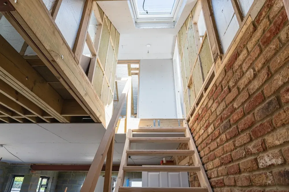 A loft mid-build showing the new timber frame, insulation and staircase