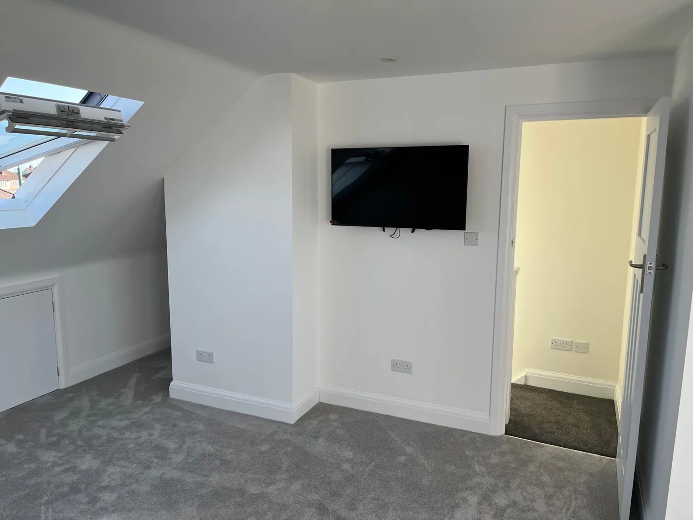 Loft conversion bedroom with a Velux window and neutral decor