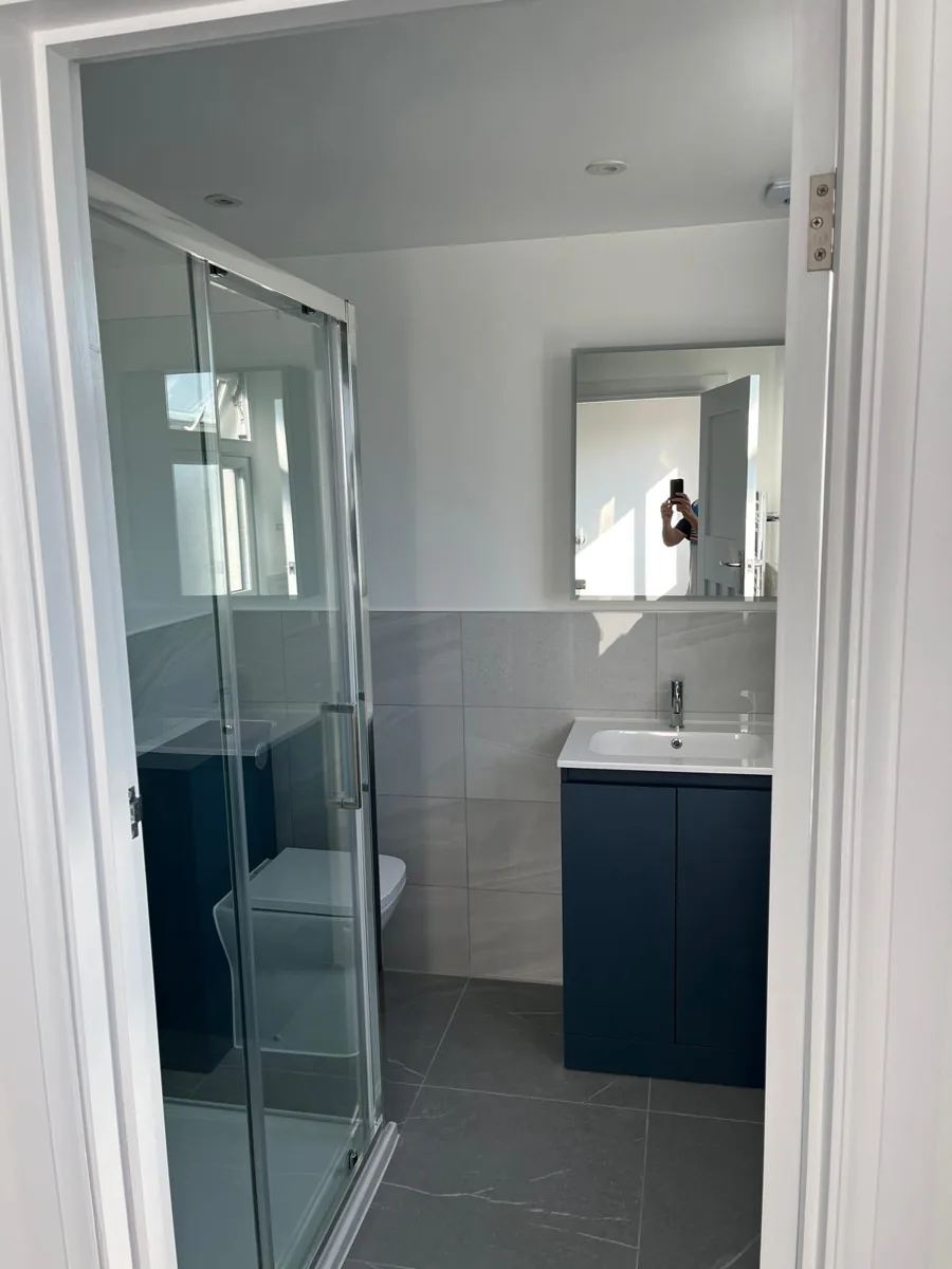 Loft shower room with a glass enclosure and navy vanity unit