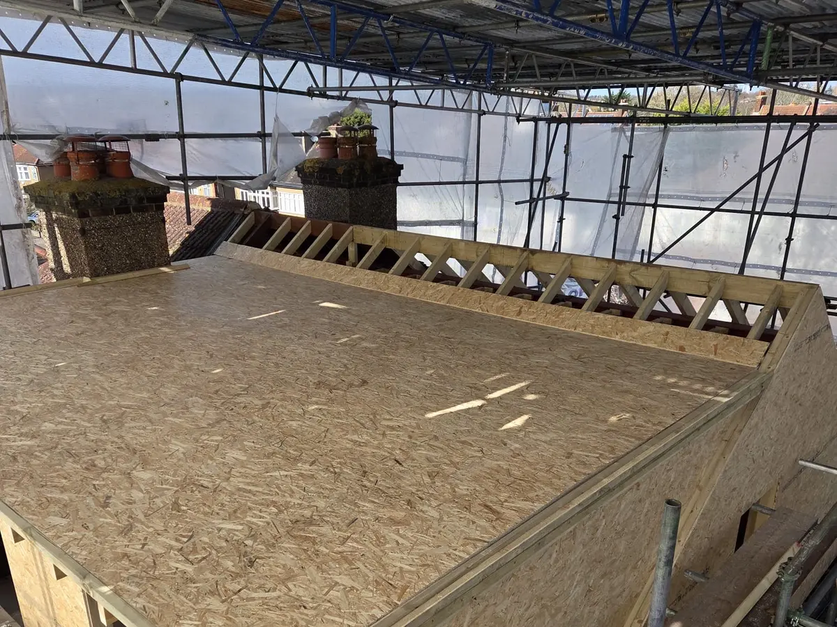 The same roof with the hip removed and a new structural floor deck laid across the joists