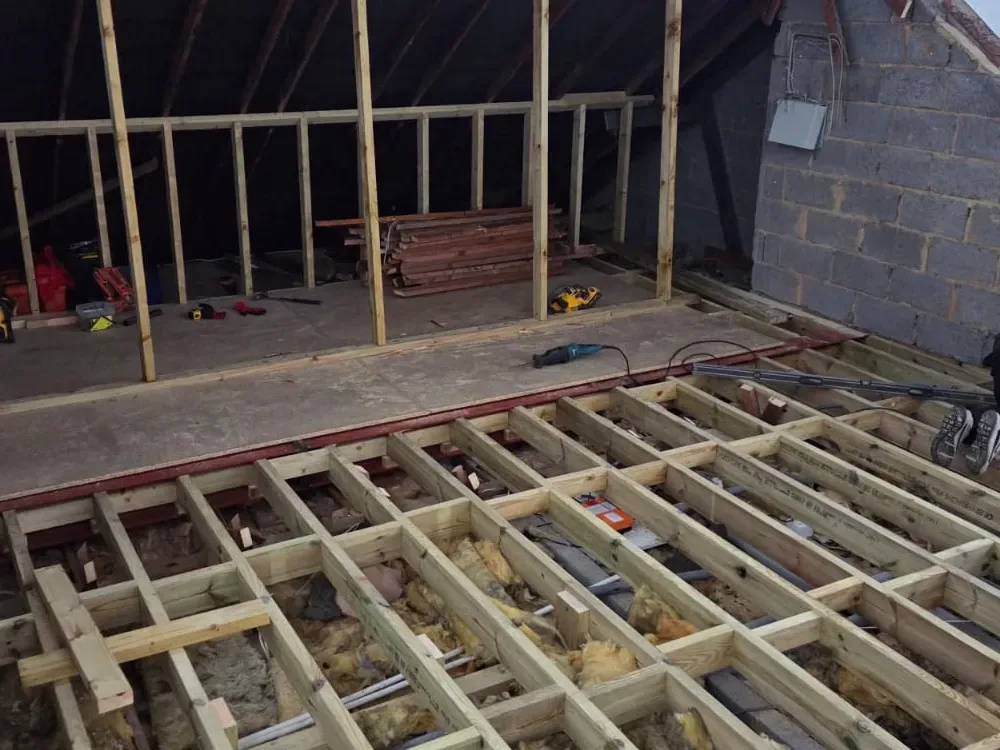 New floor joists and a steel beam installed in a loft during a trussed roof conversion